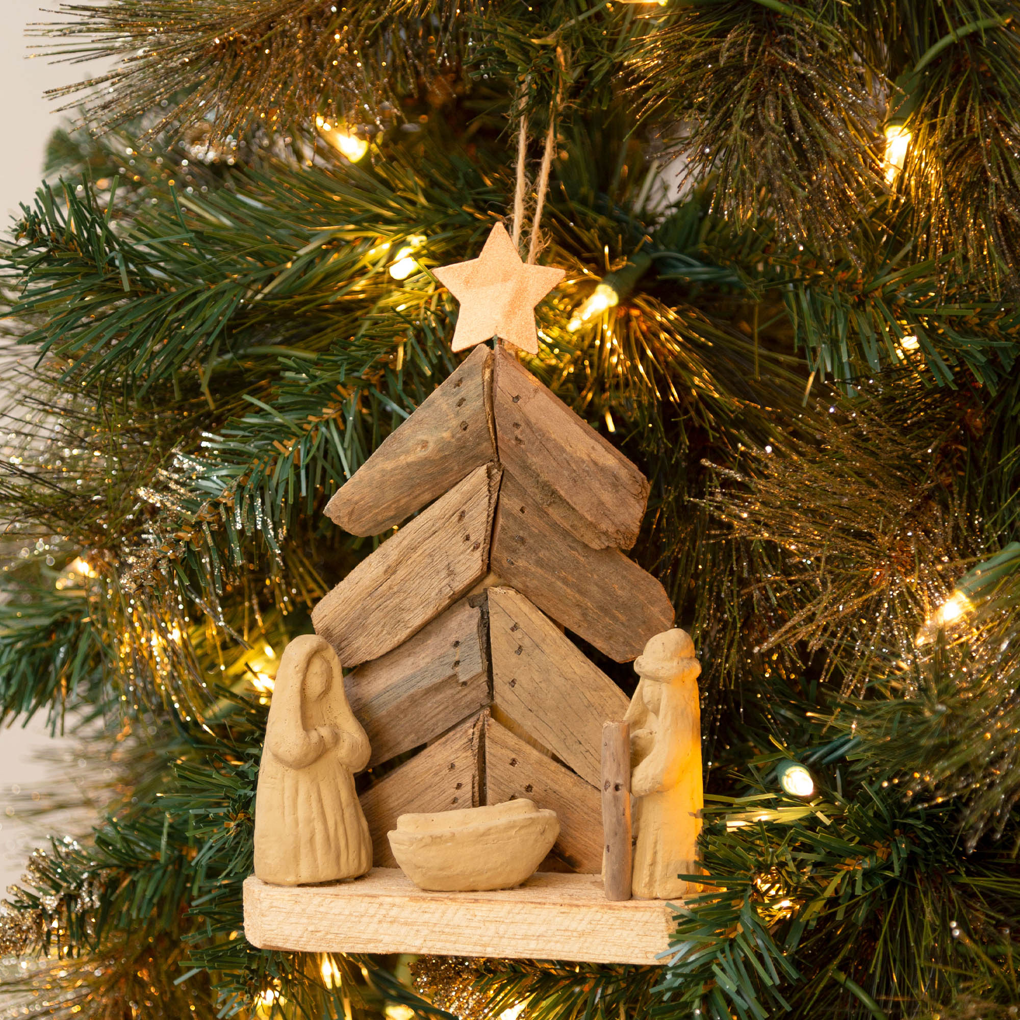 Recycled driftwood nativity ornament with clay figures and moss accent, handmade for eco-friendly holiday decorating.