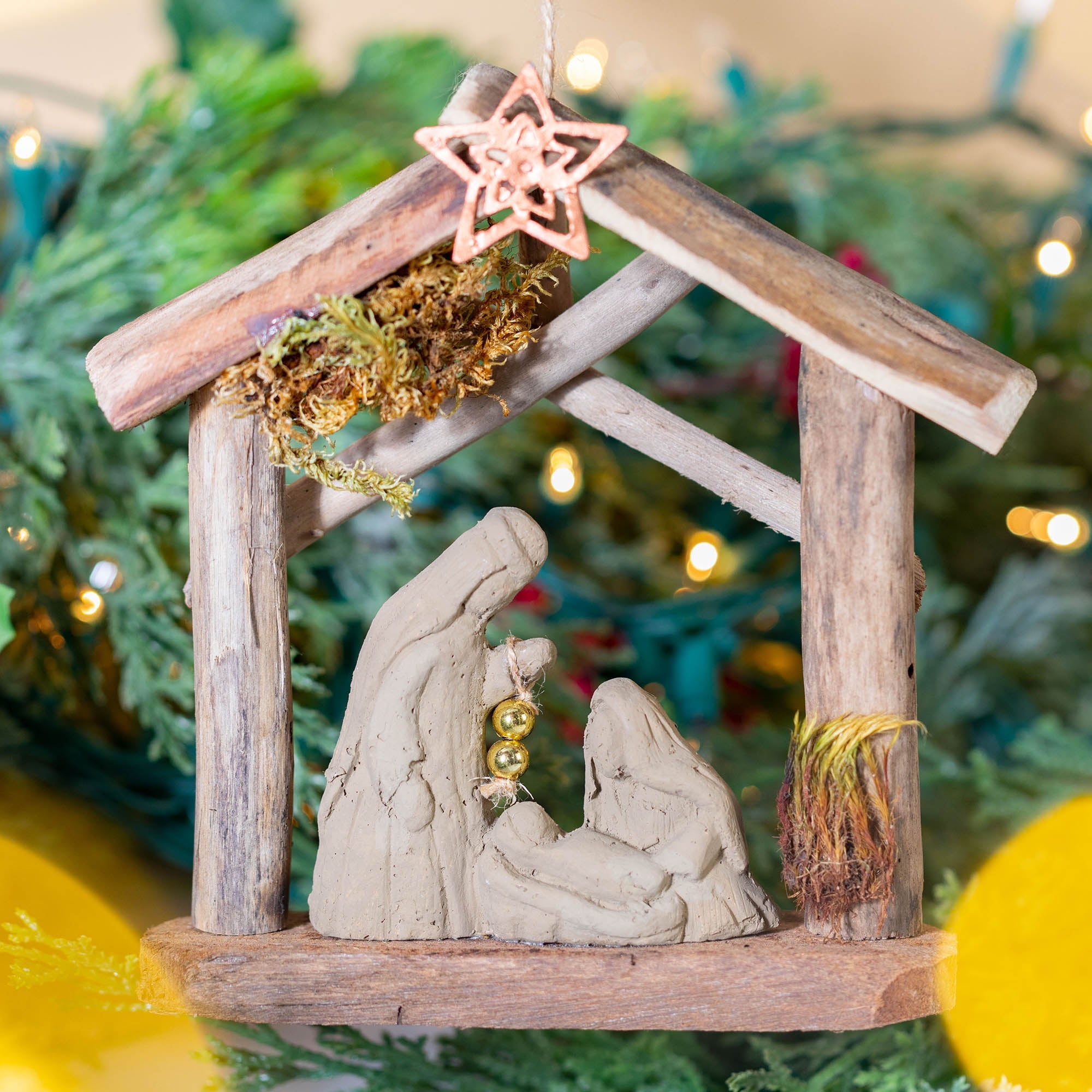Handmade recycled driftwood nativity ornament with clay figures and copper star, a unique sustainable holiday decoration.