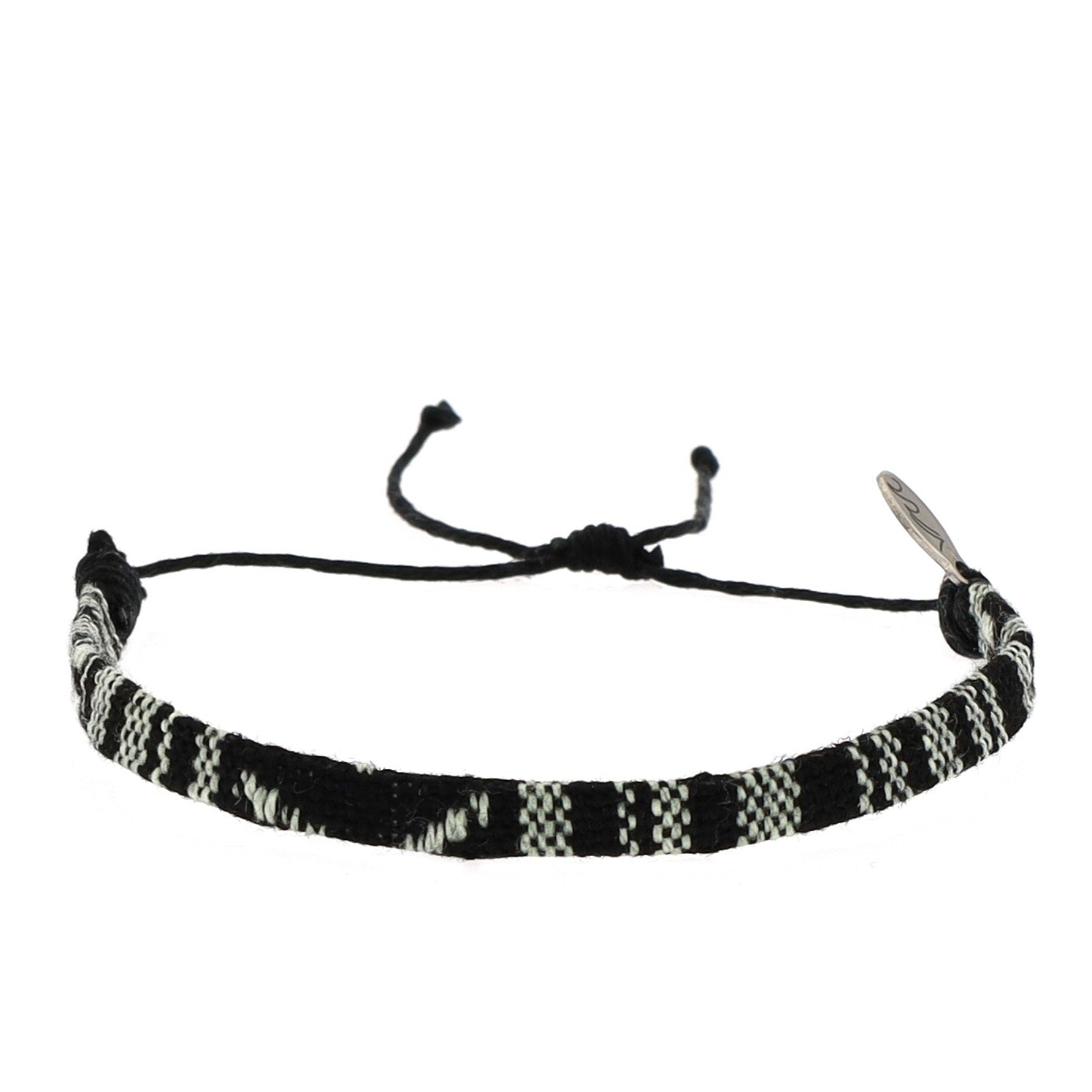A woven Night Sky black and white. Features adjustable cotton-blend cords and a sustainable stainless steel charm. Each bracelet helps remove one pound of trash from waterways.