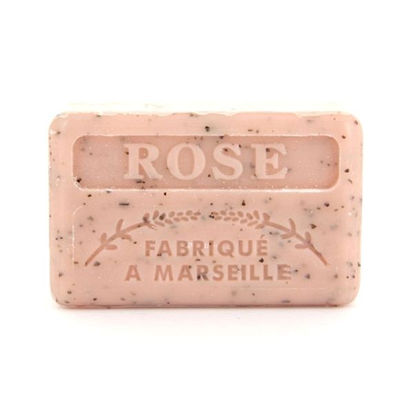 A light pink French soap bar with dark specks is embossed with the words "ROSE" and "FABRIQUÉ A MARSEILLE".