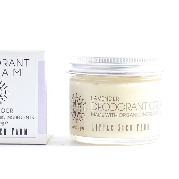 A jar of pale yellow Little Seed Farm Lavender deodorant cream is shown next to its white box. made with organic ingredients.