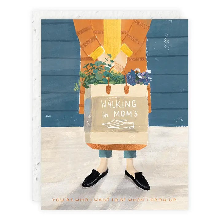 A seedling card showing a person from the shoulders down wearing a yellow scarf and brown jacket, holding a tote bag filled with plants. Text reads: "Walking in Mom's shoes. You're who I want to be when I grow up."