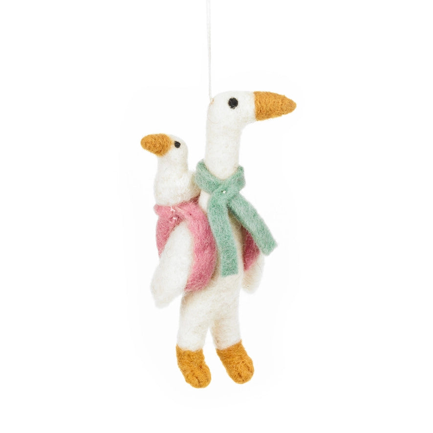 A handmade felt hanging ornament of two geese is shown, with a small goose riding on the back of a larger one.
