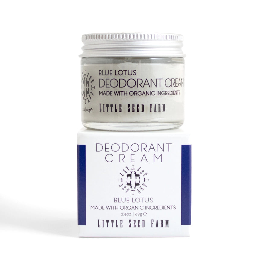A jar of Little Seed Farm deodorant cream is shown resting on its product box. The cream is a "Blue Lotus" scent and is made with organic ingredients. The packaging is white and blue with black lettering.