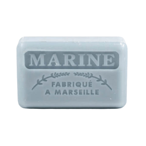 A light blue French soap bar is embossed with the words "MARINE" and "FABRIQUÉ A MARSEILLE".
