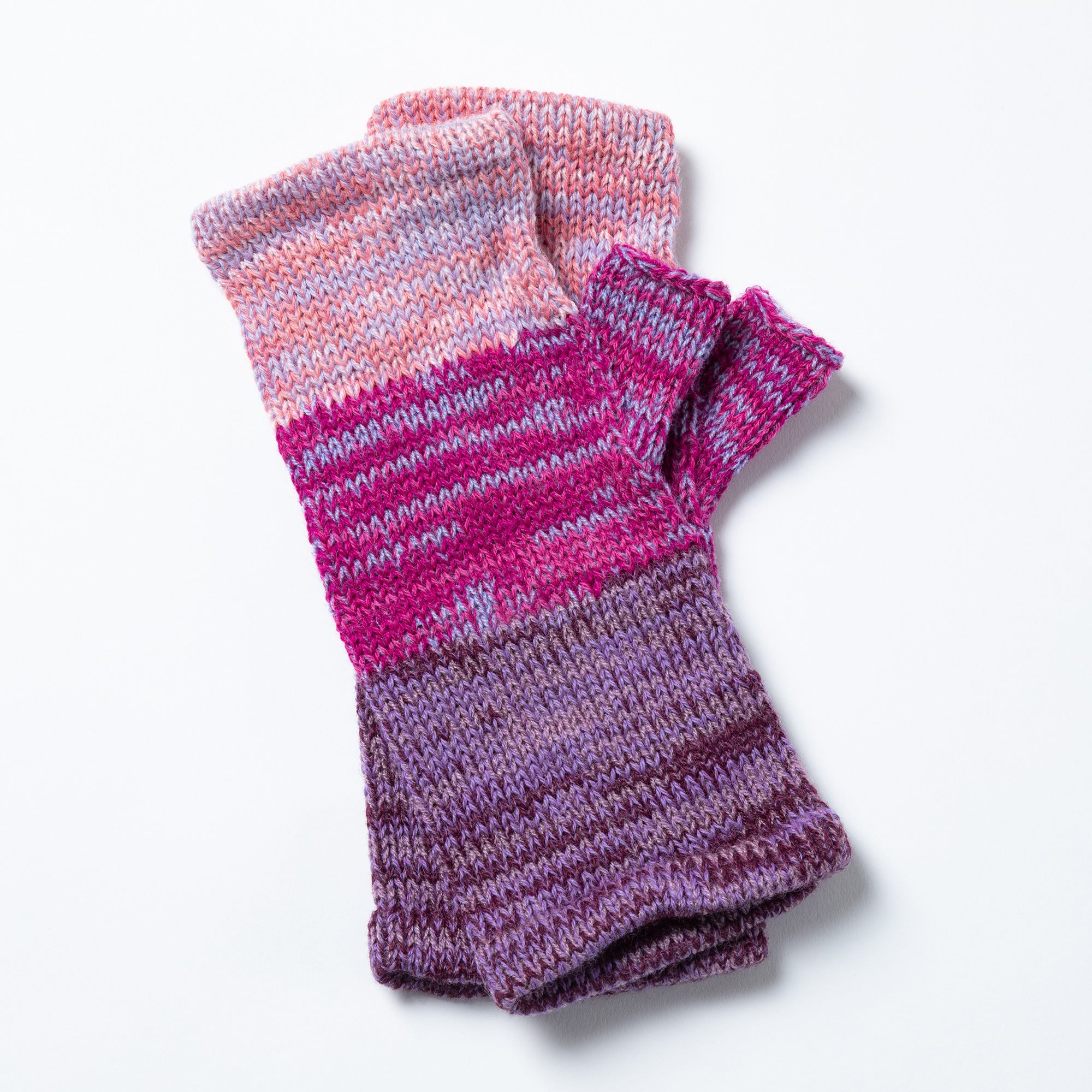 Purple and pink fingerless mittens made from soft alpaca yarn, hand-knit with a vibrant, textured pattern.