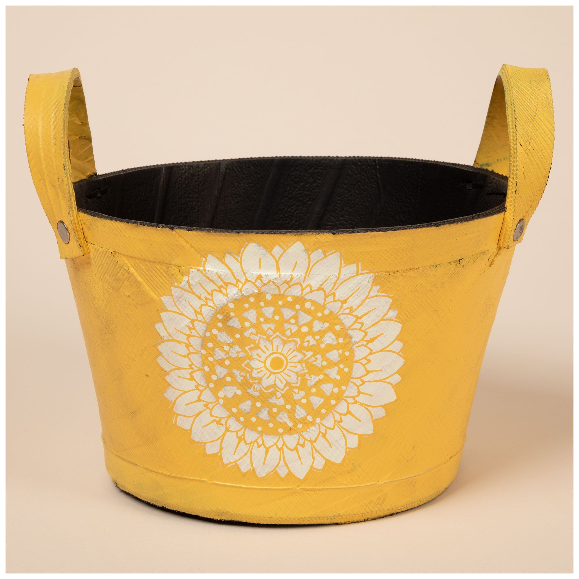 Yellow recycled-rubber planter with a white sunflower centered on the front. Handles on each side and a visible black interior.