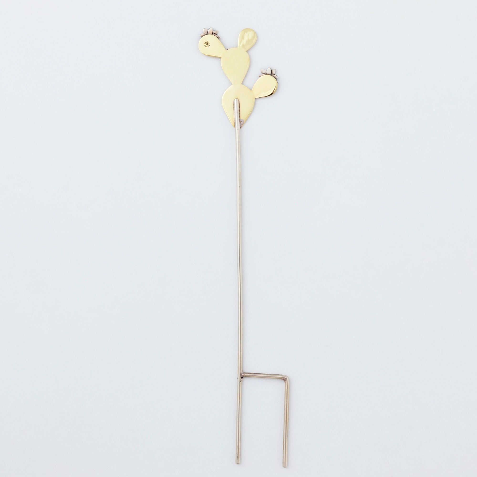 Back view of the handmade cactus plant stake, crafted from alpaca silver and brass with a sturdy pronged base.