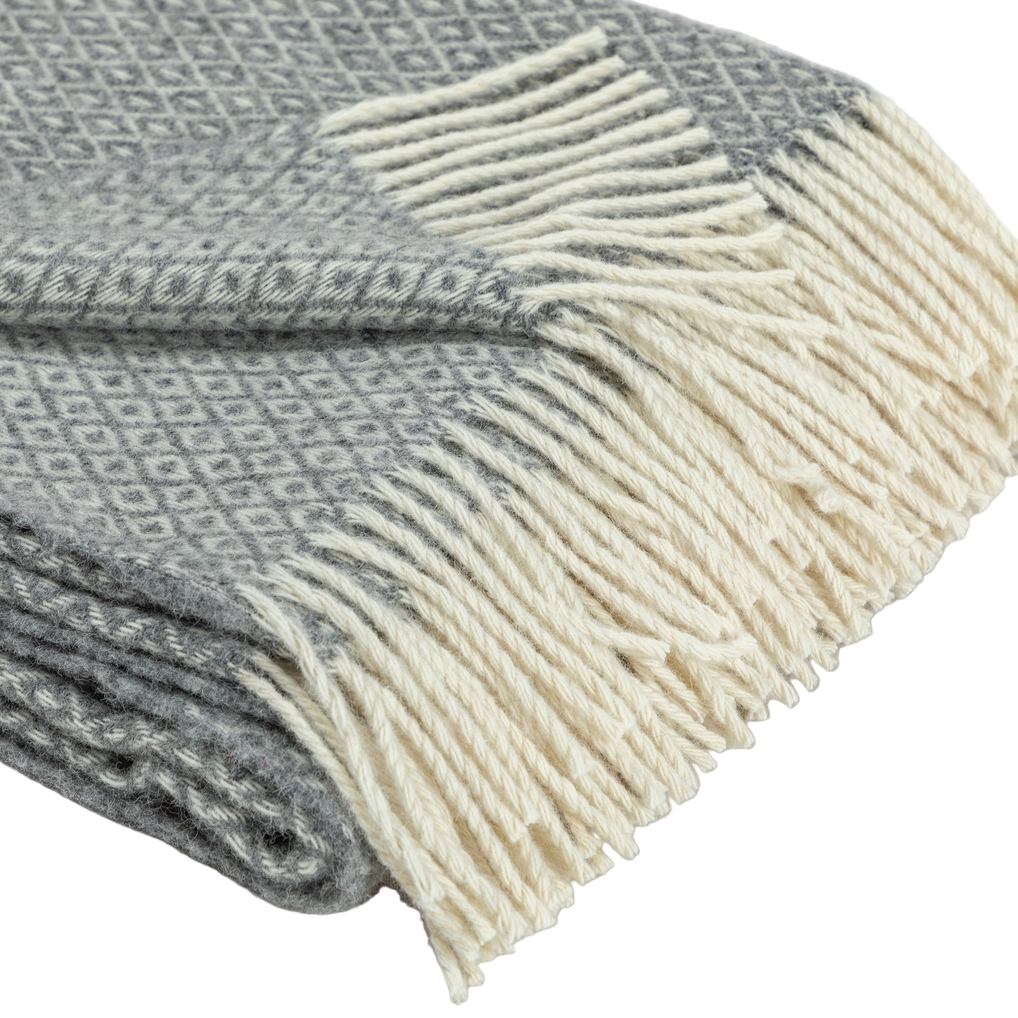 Close-up detail of the Ukrainian wool blanket showing the soft, textured fabric and cream-colored fringes along the edge. The pattern consists of small diamonds in a gray color palette.