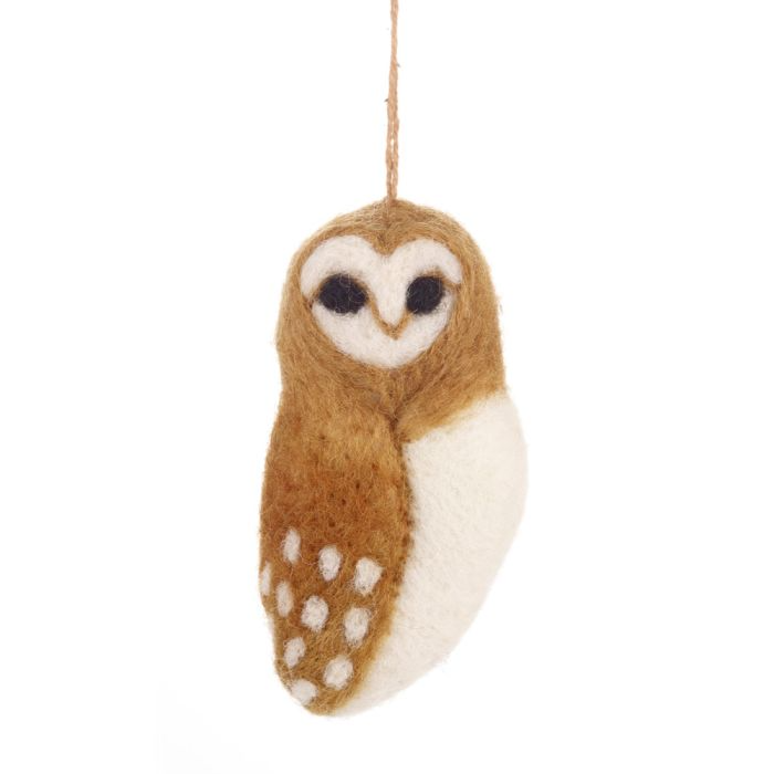 A handmade felt barn owl. It has a brown body with white spots on the wings and a white head and belly.