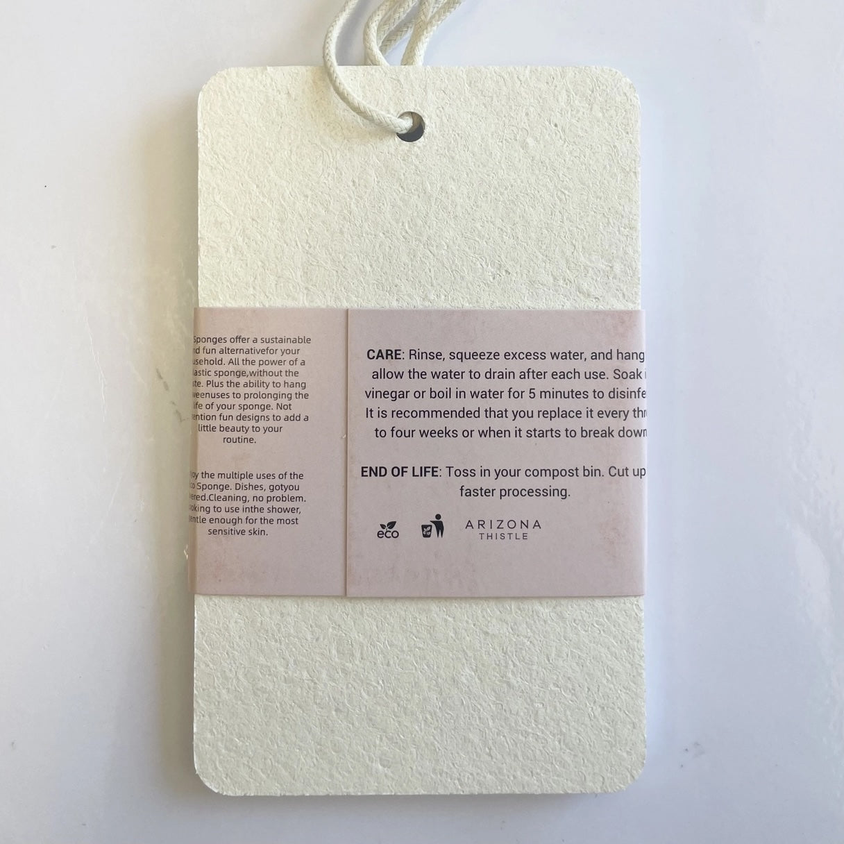 Pack of three compostable eco sponges with the paper sleeve label seen from the back, safe for dishwasher and microwave sanitizing.