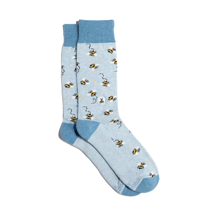 A pair of light blue Conscious Step socks is shown against a white background. They have a pattern of yellow and black bees and feature a small bee logo on the side.