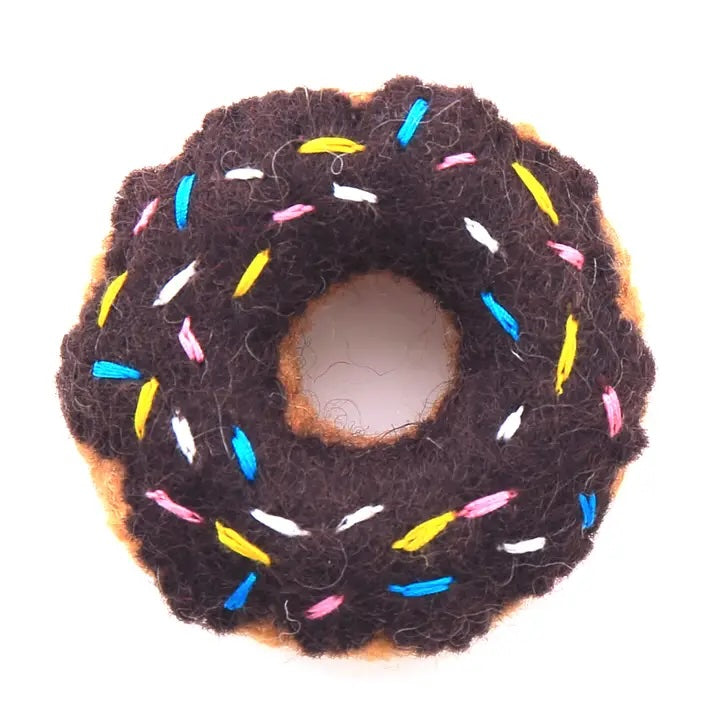 A wool donut toy with brown “chocolate” frosting and colorful sprinkles, crafted with Fair Trade wool.