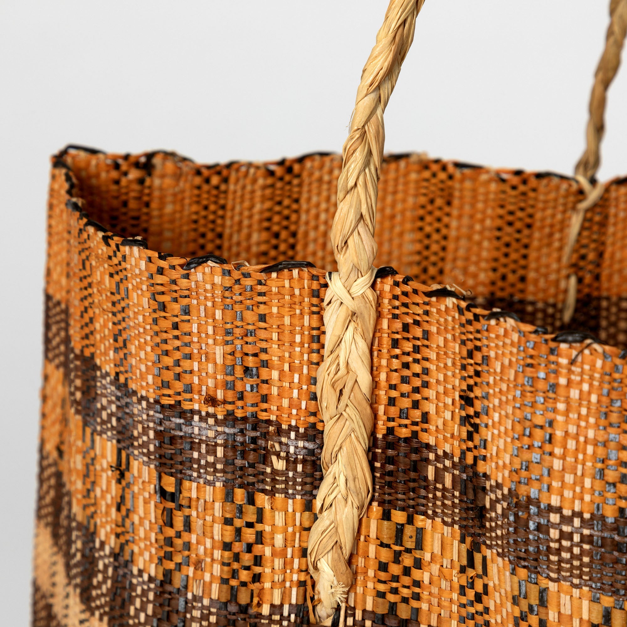 Close-up of the handwoven grass fibers and vegetable dye patterns on the African artisan tote bag. Lightweight and flexible with braided handles, handmade in the Democratic Republic of Congo.
