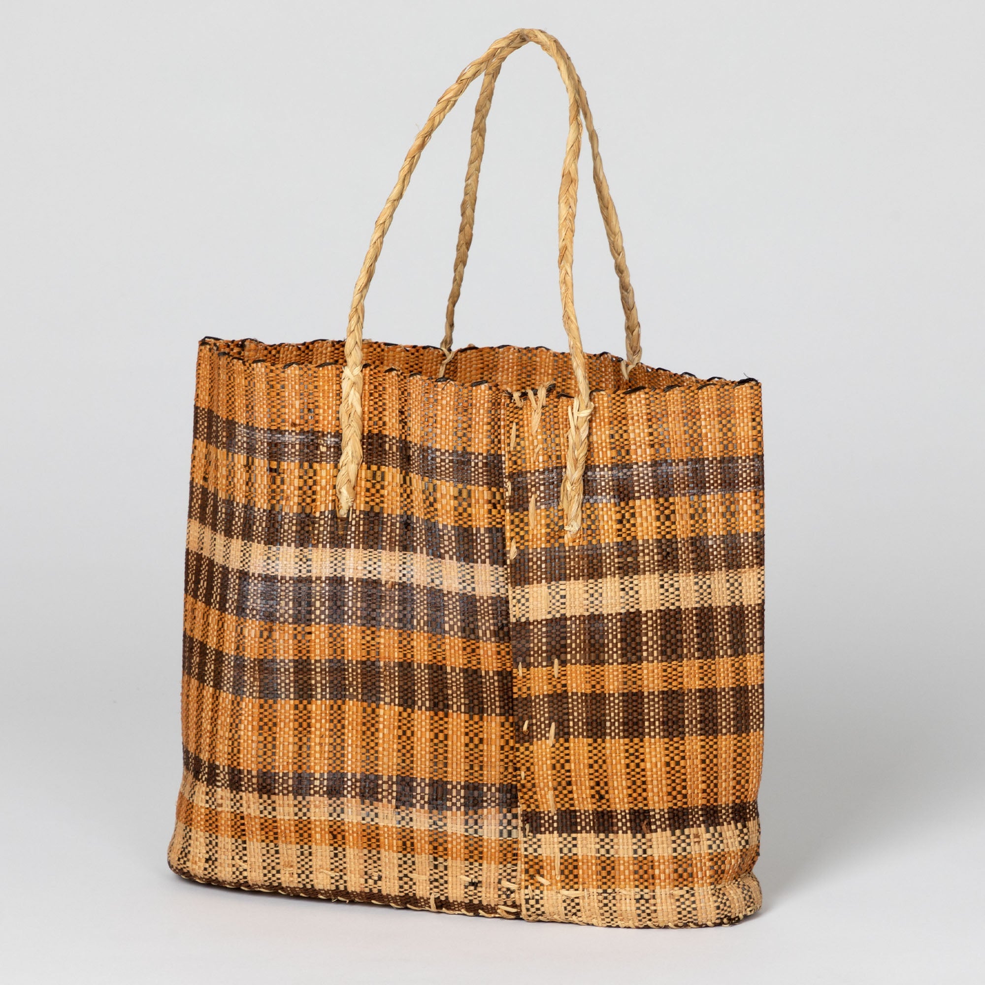 Handwoven African tote bag in warm brown tones, showcasing natural texture and open design. Crafted by artisans supporting sustainable income in the Democratic Republic of Congo.