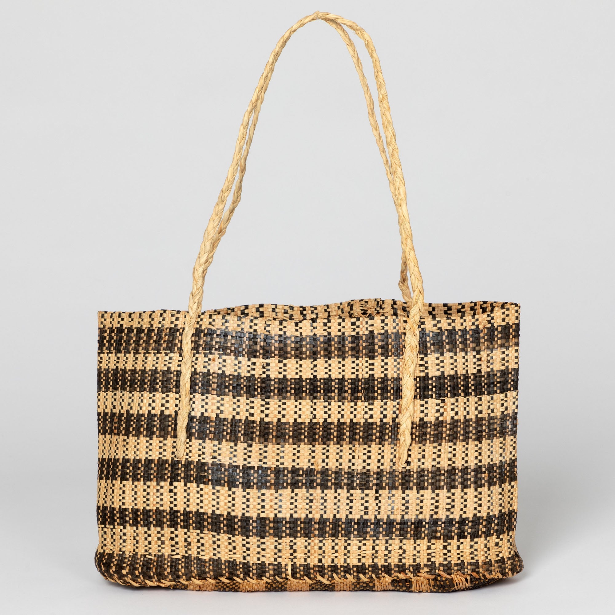Earthy palm-colored handwoven African tote bag highlighting its flexible, open weave. Handmade by artisans contributing to community livelihoods in the Democratic Republic of Congo.