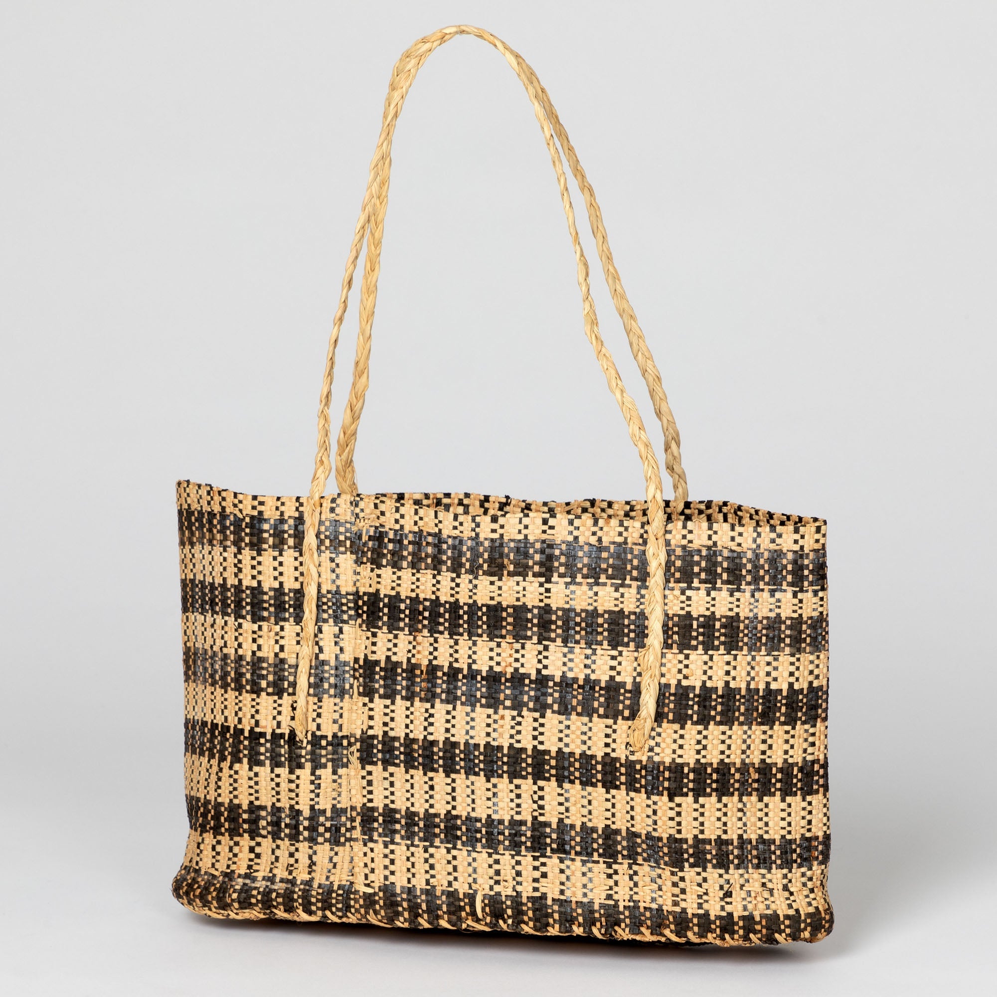 Natural brown handwoven African tote bag with braided handles and open construction. Supports fair-trade artisans in the Democratic Republic of Congo.