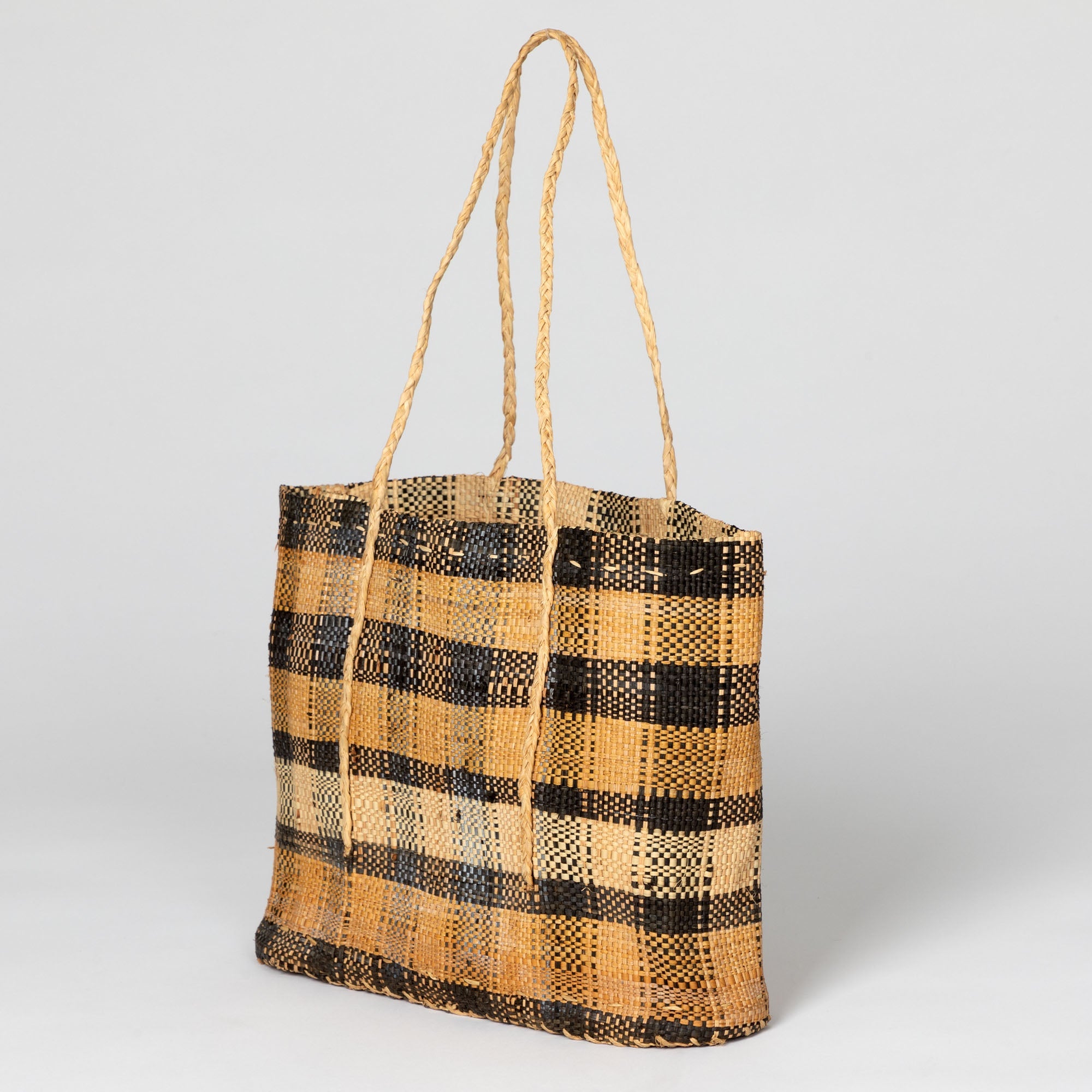 Palm-hued handwoven African tote bag emphasizing its natural fibers and lightweight feel. Handmade by artisans supporting sustainable development in the Democratic Republic of Congo.