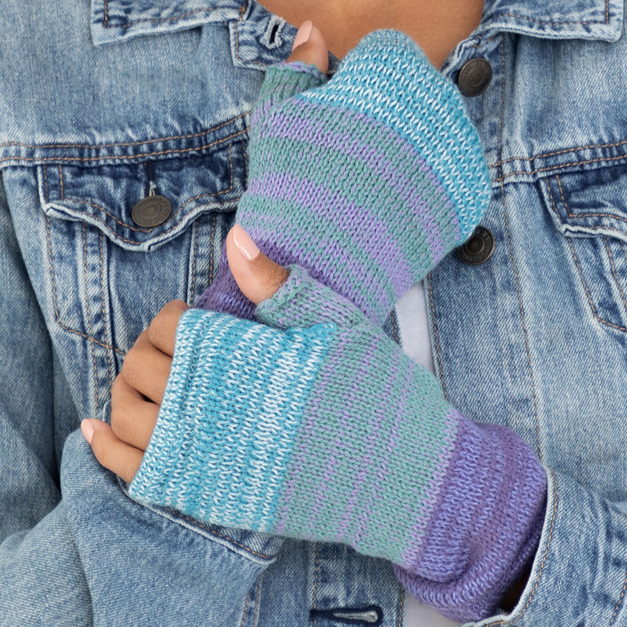 Hands shown wearing handmade alpaca fingerless mittens in a blue, gray, and purple color combination. Soft, hypoallergenic, and made in Bolivia.