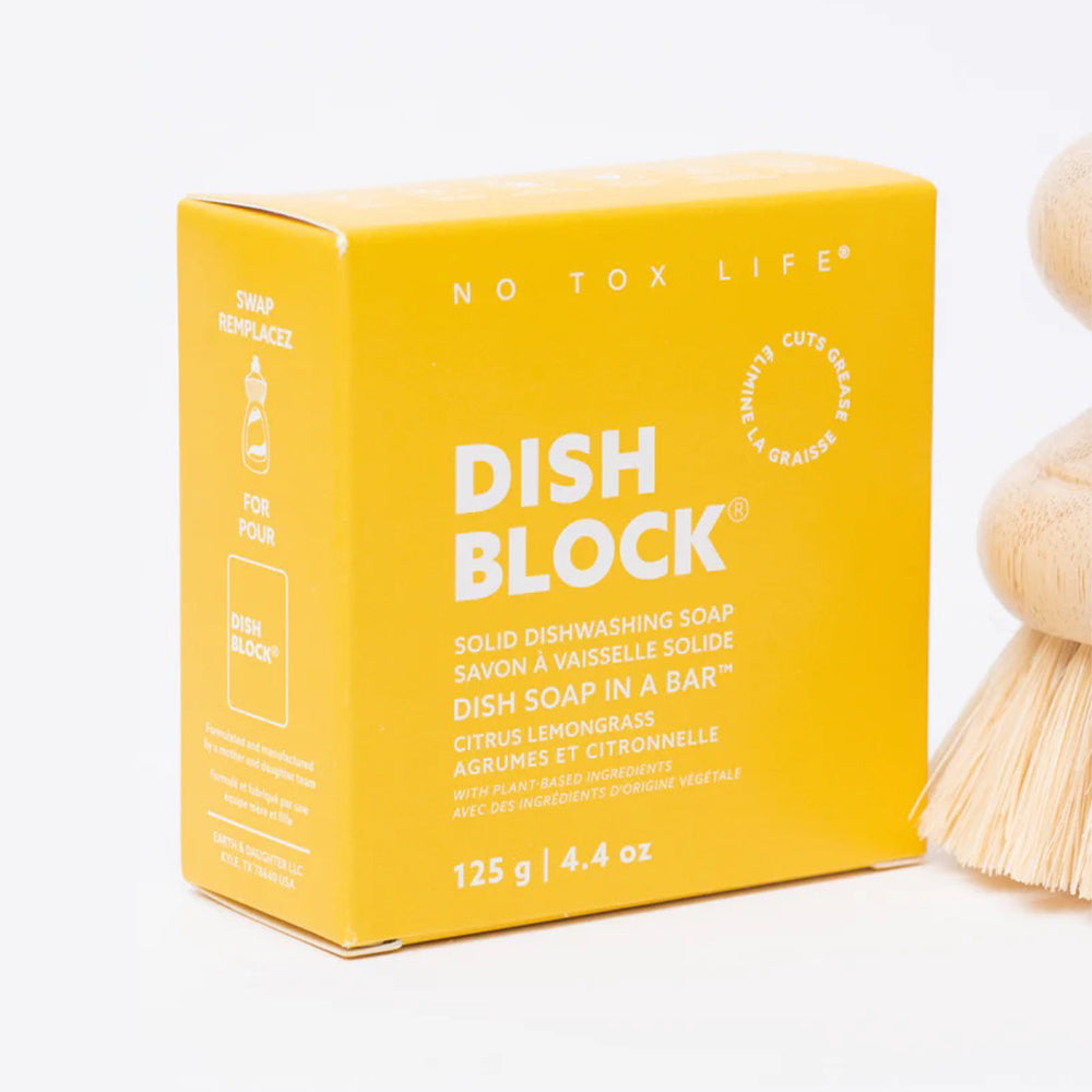 Yellow box of Dish Block solid dishwashing soap with a wooden brush on a white background