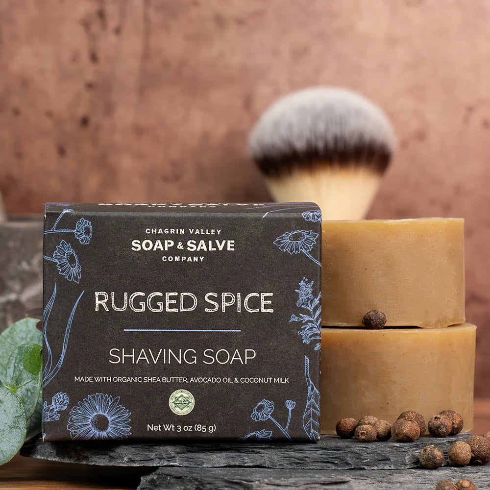 Rugged Spice shaving soap bar with packaging and a brush on a wooden surface