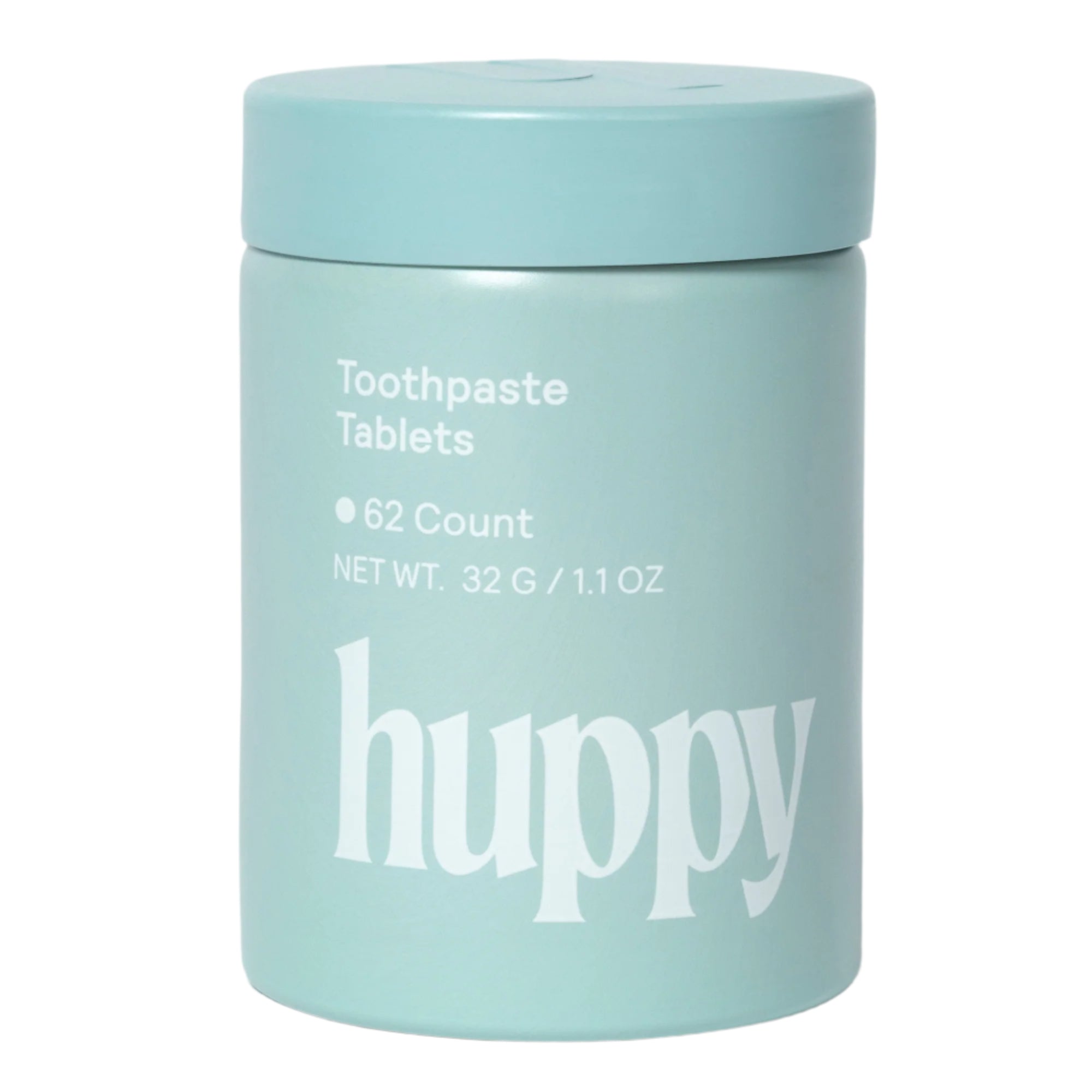 A sealed 'huppy' jar of toothpaste tablets stands upright, with "Toothpaste Tablets" printed on the light blue container.