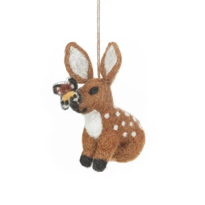 A handmade felt fawn is shown, with a brown body and white spots and belly. The fawn is holding a small butterfly in its snout.