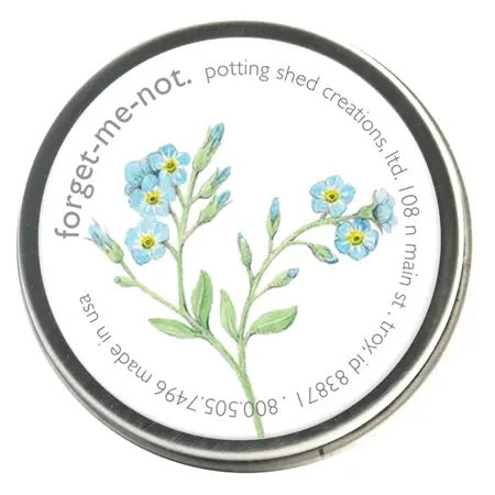 A silver tin of garden sprinkles with a white label on the lid. The label features a watercolor illustration of a sprig of light blue forget-me-not flowers, with the text 'forget-me-not, potting shed creations' around the edge.
