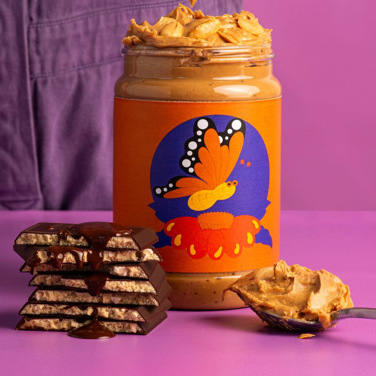 Pieces of the Maeve “Peanut Butter Fly” chocolate bar next to a peanut butter jar.