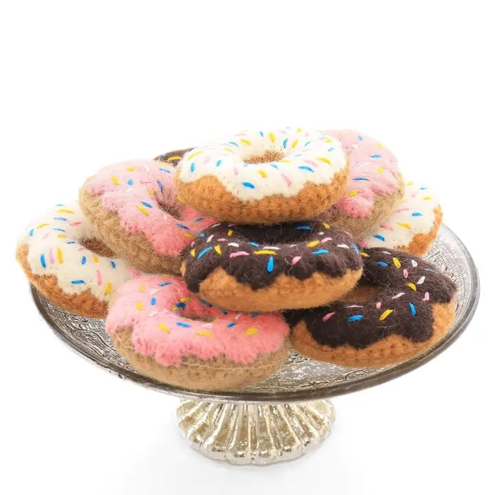A group of felted wool donut cat toys in assorted colors, naturally dyed and infused with catnip.