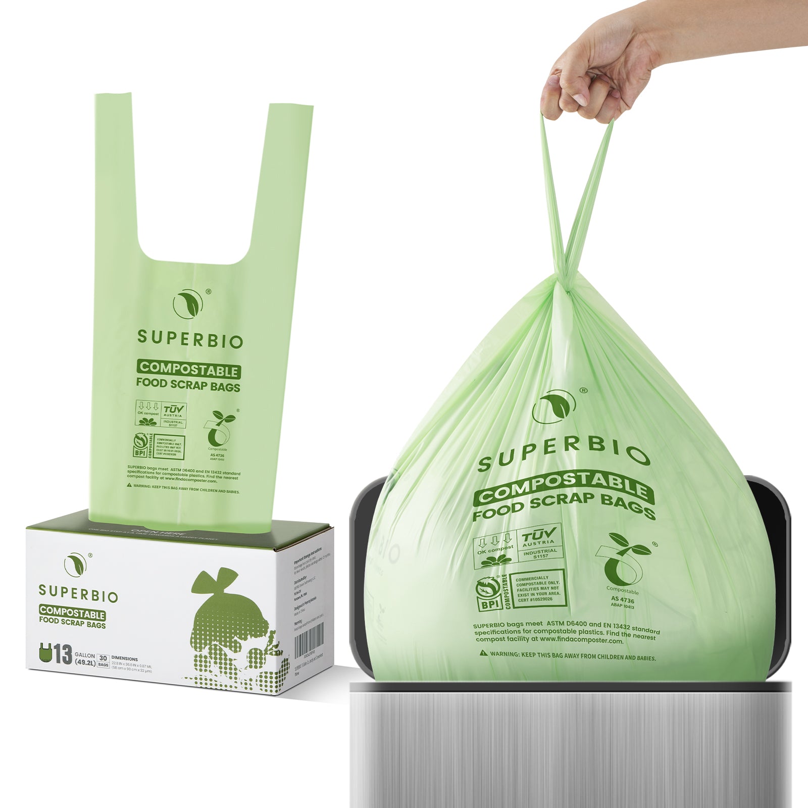 A hand is shown placing a green SUPERBIO compostable food scrap bag inside a small, stainless steel trash can. The cardboard box for the bags is also visible in the background.