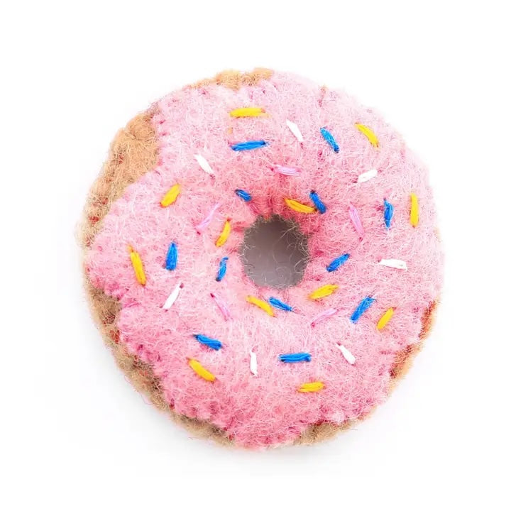 A wool donut toy with pink “frosting” and sprinkles, made with natural wool and organic catnip.
