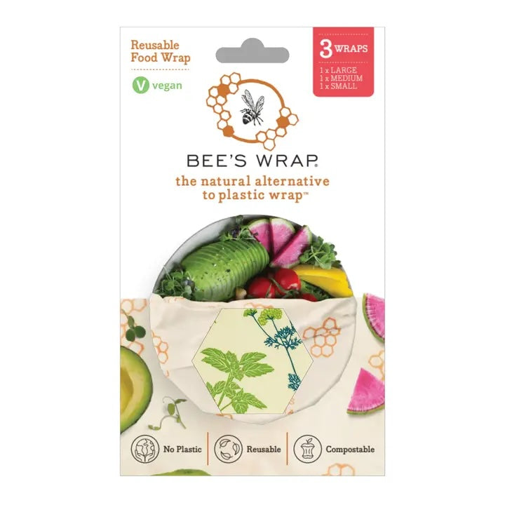 Packaging for Bee’s Wrap reusable food wraps showing a hexagonal window with a nature-themed pattern and fresh vegetables inside the wrap.