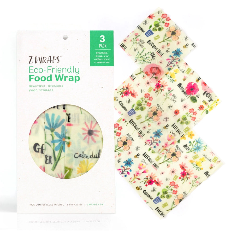Three reusable beeswax food wraps in colorful flower patterns are folded and displayed on a neutral background, showing small, medium, and large sizes with a package labeled as "3 ZWRAPS."