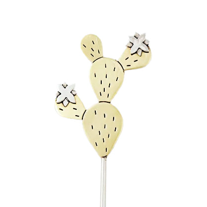 A handmade cactus plant stake crafted from alpaca silver and brass, featuring etched details and flowers. Made in Mexico by skilled Cuervo artisans.