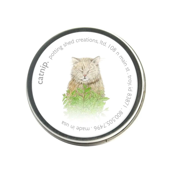 A charming catnip tin with a blissful cat among green leaves. The label includes the brand “potting shed creations” contact info and "made in USA"