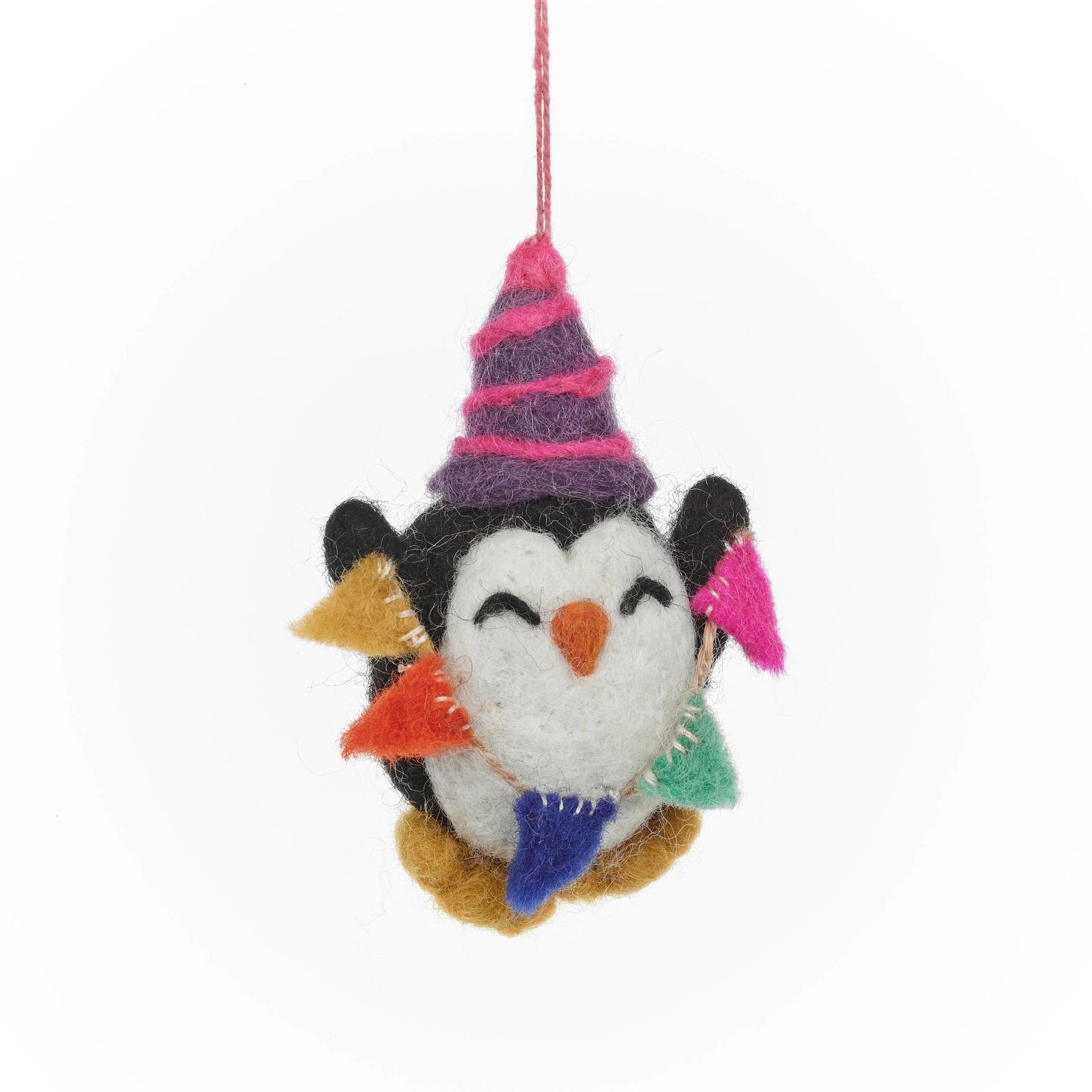 A handmade felt penguin hanging ornament is shown, wearing a striped party hat and holding a multicolored party bunting.
