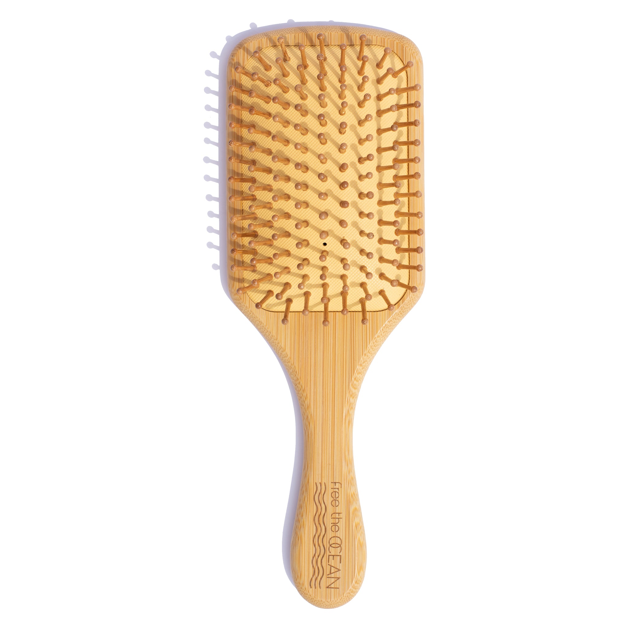 Close-up of an eco-friendly FTO bamboo hairbrush showing bamboo bristles and a smooth beeswax-coated handle on a white background.
