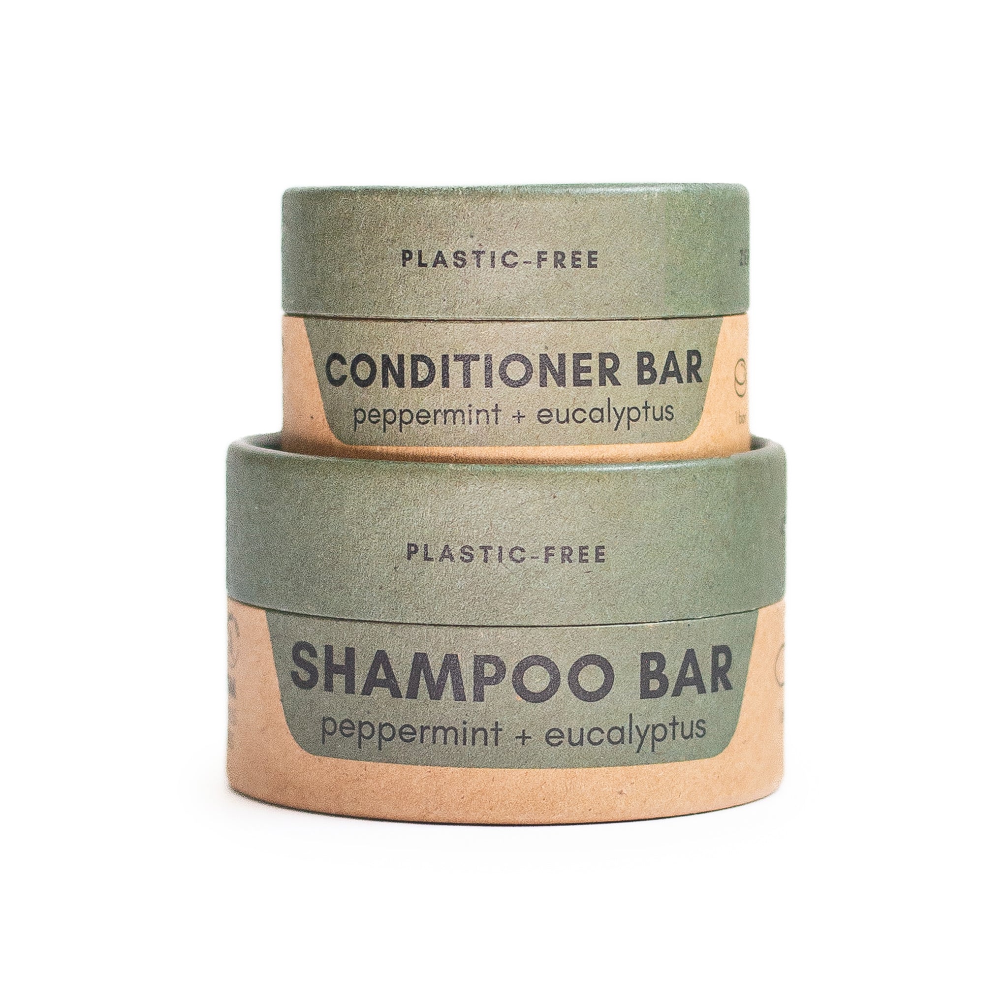 A cardboard box for a "PLASTIC-FREE SHAMPOO BAR" and another box for a "PLASTIC-FREE CONDITIONER BAR" are stacked on top of each other. Both are labeled with "peppermint + eucalyptus". The boxes are two-toned with a green top and a bamboo bottom.