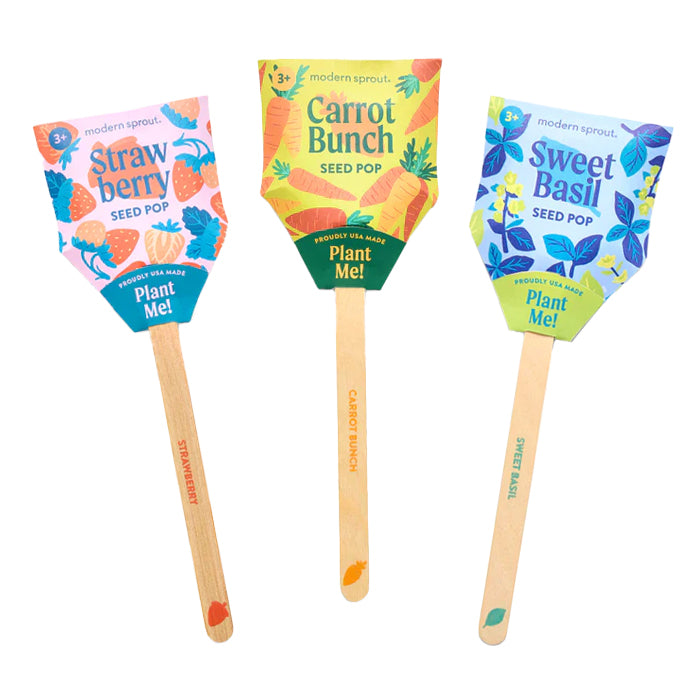 Three colorful seed pops for planting, with varieties for strawberries, carrots and sweet basil. Each has a fun illustrative design on its packaging.