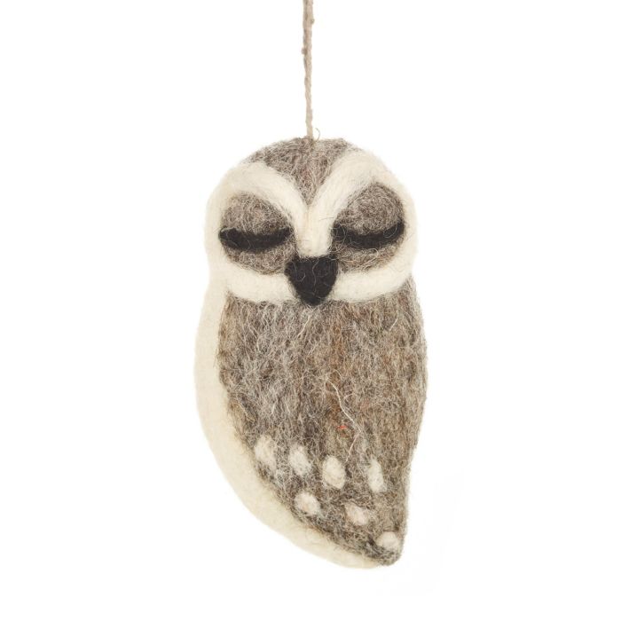 A handmade felt owl with a gray body and closed eyes is shown. It has a white face with white spots on its gray wings.