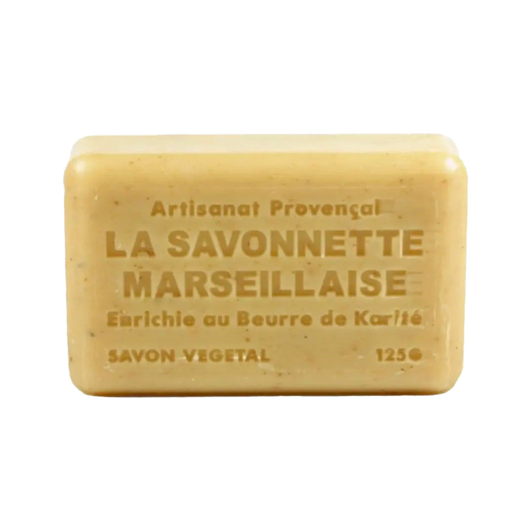 The light tan soap bar is embossed with several lines of French text, including "Artisanat Provençal" and "LA SAVONNETTE MARSEILLAISE". The bar, which weighs 125g, is also marked as a vegetable soap and "Enrichie au Beurre de Karité" (enriched with shea butter).