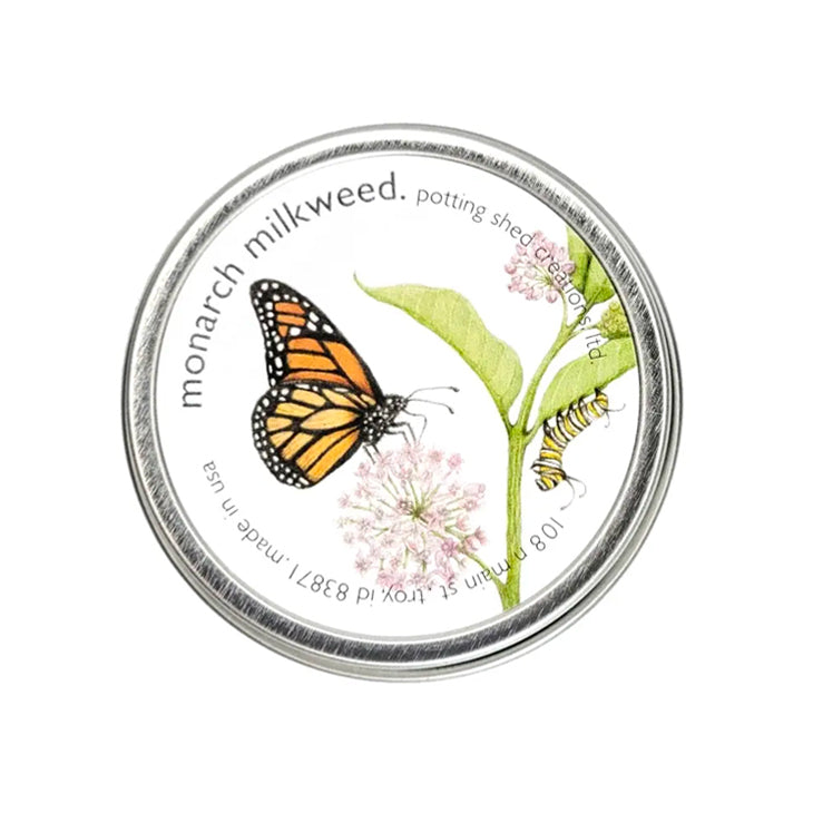 A silver tin of garden sprinkles with a white label on the lid. The label features a watercolor illustration of a monarch butterfly and a caterpillar on a pink milkweed flower, with text reading 'monarch milkweed, potting shed creations'.