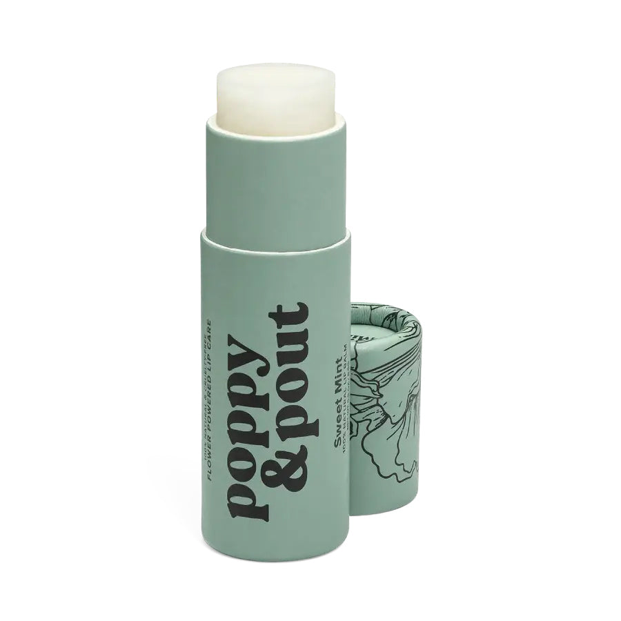 Close-up of a Sweet Mint Poppy & Pout lip balm in a compostable cardboard tube on a neutral background.