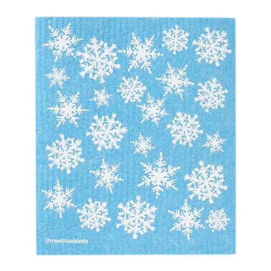 A vibrant blue background covered with a white snowflake pattern, featuring a winter design on this biodegradable reusable Swedish dishcloth