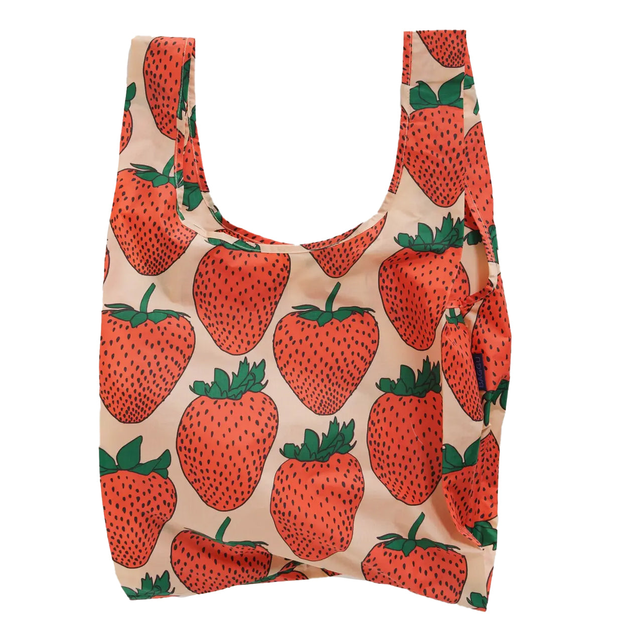 Reusable BAGGU tote in a bright red strawberry print on a pale pink background, made from recycled ripstop nylon. Holds up to 50 lbs, folds into its own pouch, and is machine washable.