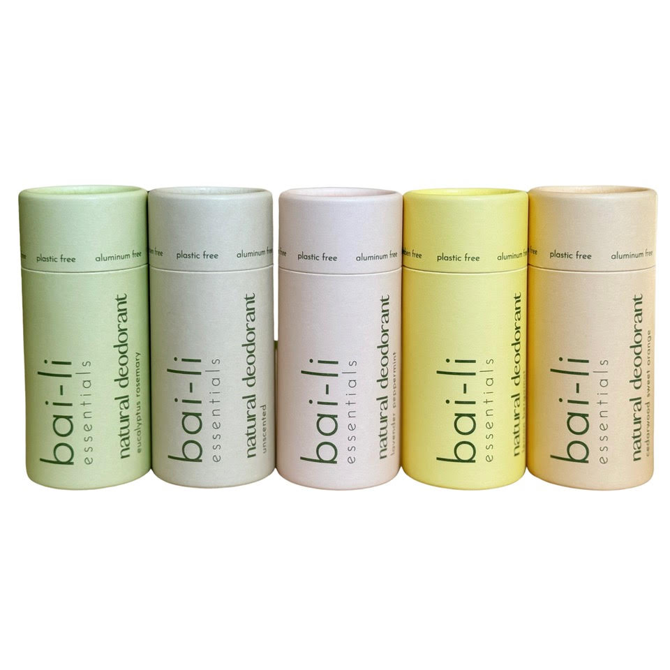Five plastic-free deodorant tubes in a compostable cardboard on a white background, displaying scent variants Lemon + Bergamot, Eucalyptus + Rosemary, Unscented, Lavender + Peppermint, and Cedarwood + Sweet Orange.