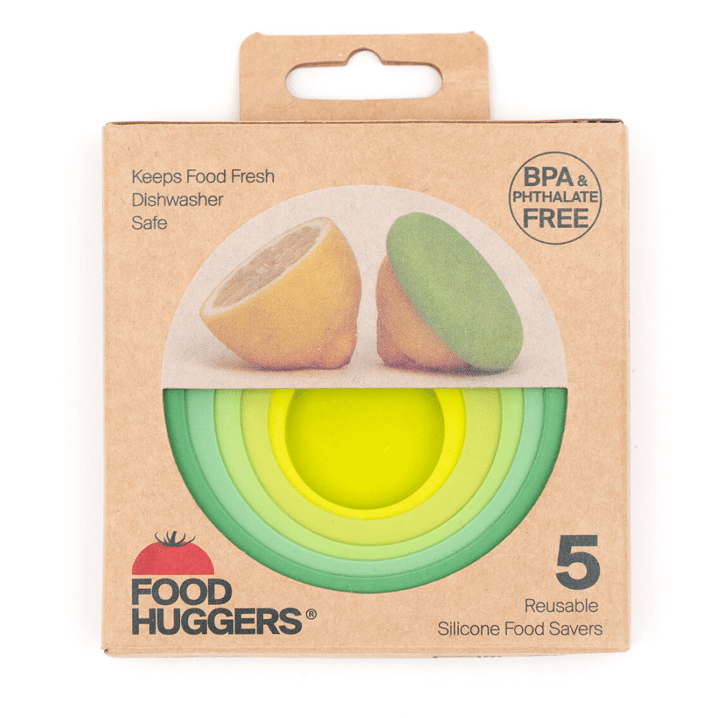 A box of "Food Huggers" reusable silicone food savers with a window showing a set in a green and yellow gradient. The packaging illustrates a saver being used to cover a lemon half, highlighting its application.