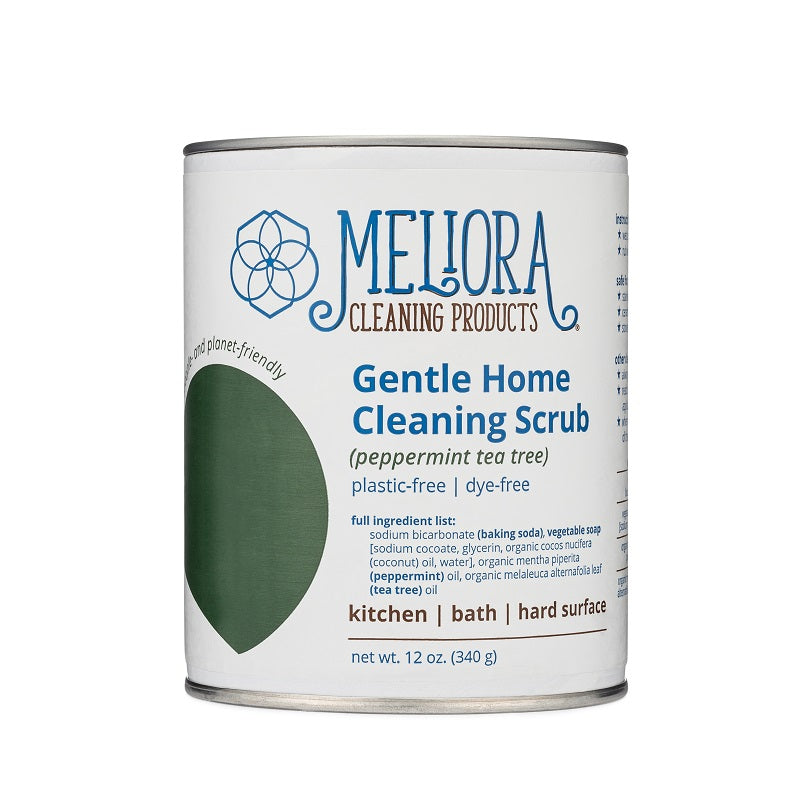 A can of Mellora Cleaning Products Gentle Home Cleaning Scrub is shown. The label indicates the scent is peppermint tea tree and lists its uses for the kitchen, bath and hard surfaces. The product is noted as being plastic-free and dye-free, with a net weight of 12 oz.