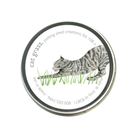A silver tin of garden sprinkles with a white label on the lid. The label features a watercolor illustration of a gray tabby cat stretching low in green grass, with the text 'cat grass, potting shed creations' around the edge.